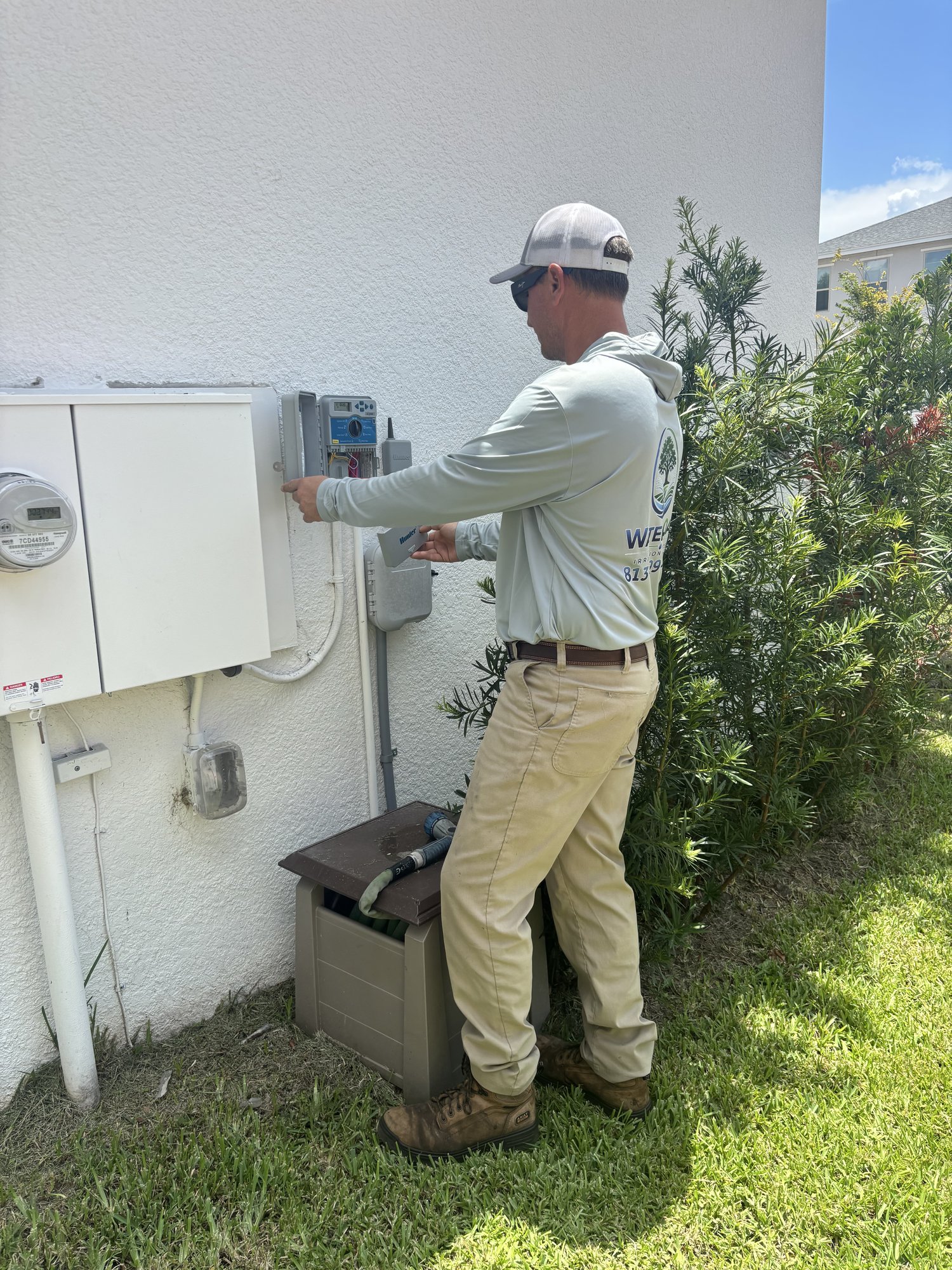 Water Oak Irrigation technician programming a smart sprinkler controller in Tampa, FL