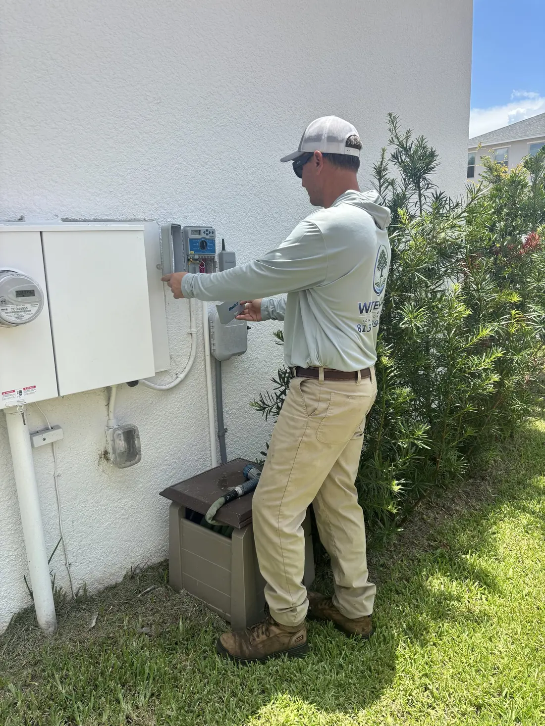 Water Oak Irrigation technician programming a smart sprinkler controller in Tampa, FL