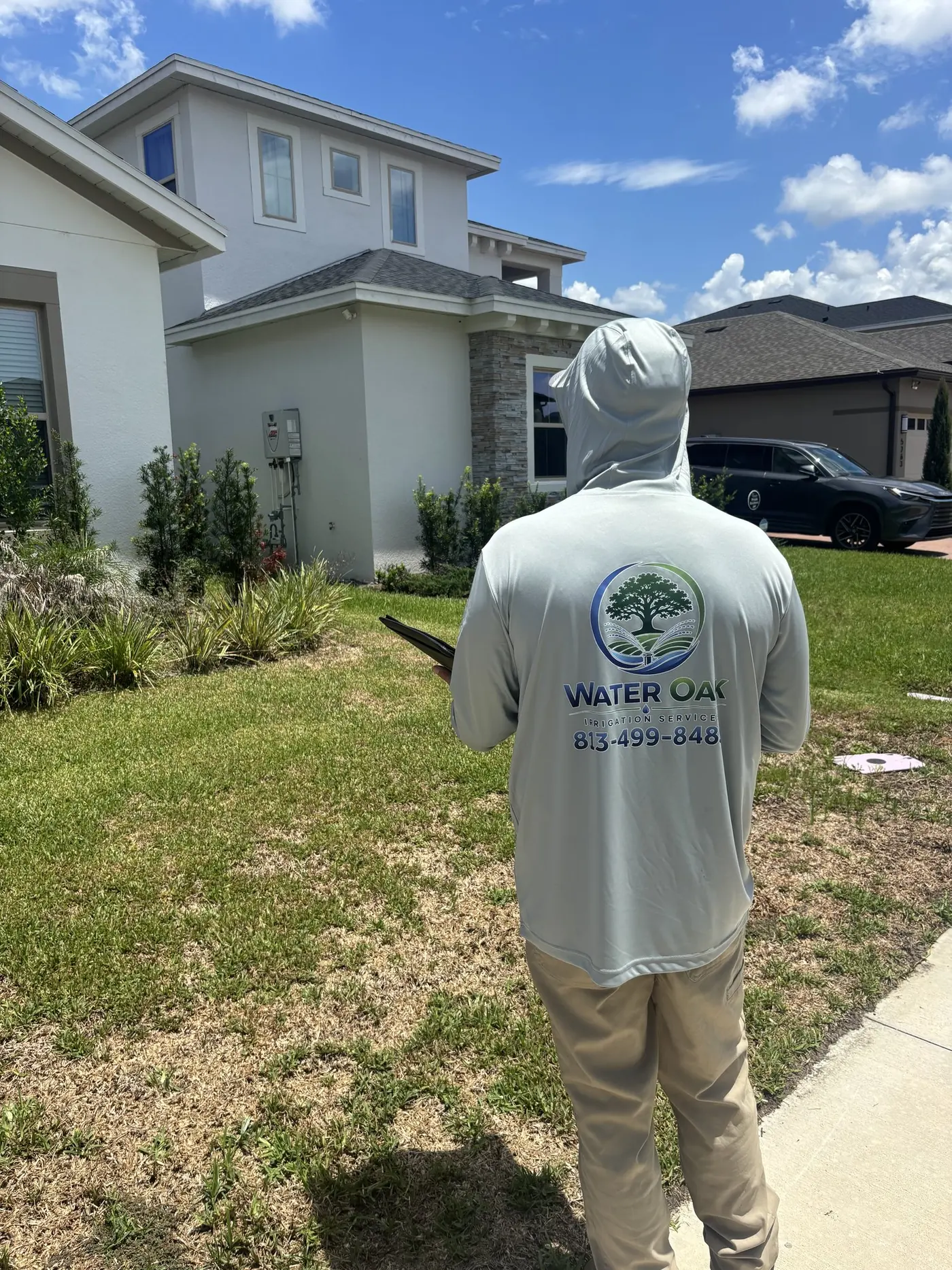 Water Oak Irrigation technician inspecting a lawn and sprinkler system in Tampa, FL